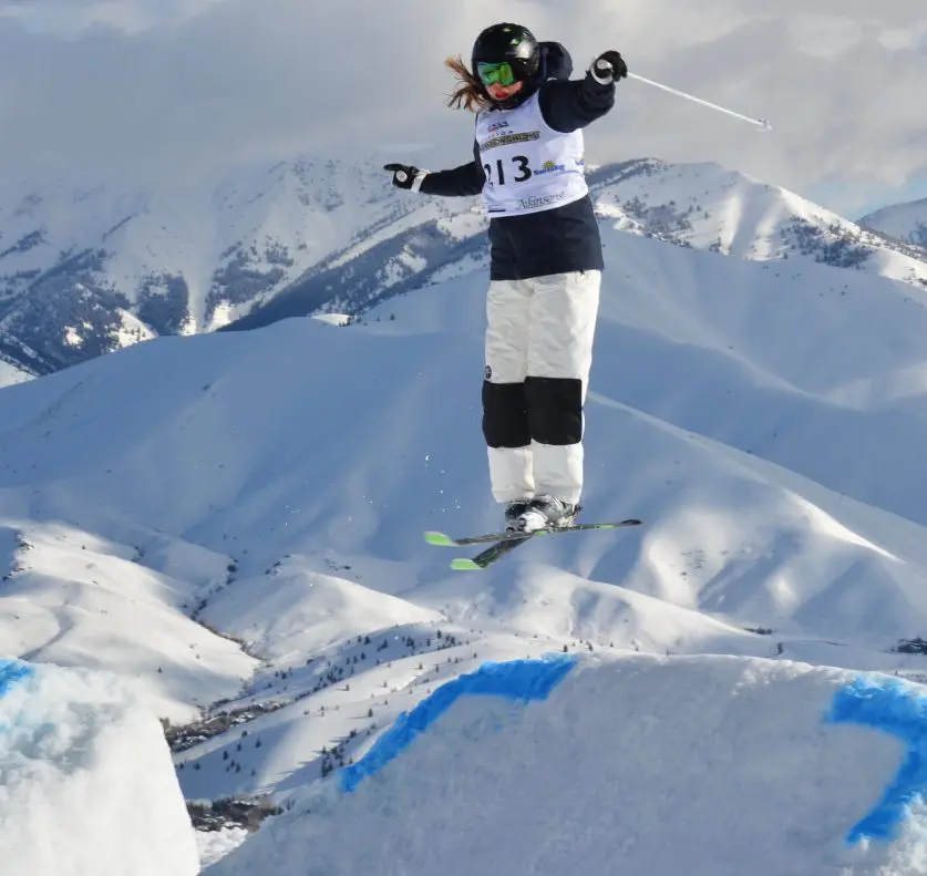 Skier jumping on snowy mountain slope.